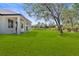 Expansive backyard with lush lawn, mature trees, and white exterior home at 2143 S Haberland Blvd, North Port, FL 34288