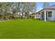 Expansive backyard with lush lawn, mature trees, and white exterior home at 2143 S Haberland Blvd, North Port, FL 34288
