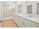 Bathroom boasts double sinks, walk-in shower with marble tile and ample lighting at 2143 S Haberland Blvd, North Port, FL 34288