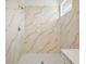 Elegant bathroom featuring marble-patterned tile walls and floor and sleek fixtures at 2143 S Haberland Blvd, North Port, FL 34288