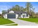 Beautiful, modern single-Gathering home with a well-manicured lawn and a paved driveway leading to a two-car garage at 2143 S Haberland Blvd, North Port, FL 34288