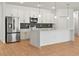 Modern kitchen with stainless steel appliances, white cabinetry, large island, and stylish backsplash, perfect for cooking at 2143 S Haberland Blvd, North Port, FL 34288
