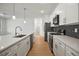 Modern kitchen features stainless appliances, black backsplash and an island with quartz countertops at 2143 S Haberland Blvd, North Port, FL 34288