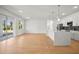 Bright, open-concept living space with wood floors, modern kitchen, and sliding glass doors to the outdoor area at 2143 S Haberland Blvd, North Port, FL 34288