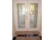 Elegant front doors featuring a decorative glass design, marble tile, and brass hardware at 21535 Edgewater Dr, Port Charlotte, FL 33952