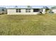 View of a large green backyard with a white single-story home at 21923 Cellini Ave, Port Charlotte, FL 33952