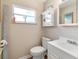 Well-lit bathroom with a vanity, toilet, and window, providing a clean and functional space at 21923 Cellini Ave, Port Charlotte, FL 33952
