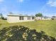 View of the home and other homes with a green lawn and trees at 21923 Cellini Ave, Port Charlotte, FL 33952