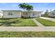 Charming single-story home featuring a well-maintained lawn and complemented by mature palm trees at 21923 Cellini Ave, Port Charlotte, FL 33952