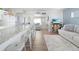 Open-concept living area with modern white kitchen, bar seating, and a comfortable seating area at 21923 Cellini Ave, Port Charlotte, FL 33952