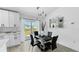 Dining room with black dining set, modern light fixtures, and sliding glass doors to the backyard at 2325 Hanford Ln, North Port, FL 34288