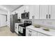 Modern kitchen with white cabinets, stainless steel appliances, and quartz countertops at 2325 Hanford Ln, North Port, FL 34288