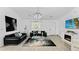 Bright living room with modern black furniture, a sleek entertainment center and modern light fixture at 2325 Hanford Ln, North Port, FL 34288