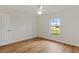 Simple bedroom with light wood floors, large window, and a white ceiling fan at 2443 Lake View Blvd, Port Charlotte, FL 33948