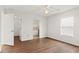 Spacious bedroom with an open closet and bathroom view, complemented by wood flooring and a bright ceiling fan at 2443 Lake View Blvd, Port Charlotte, FL 33948