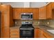Beautiful kitchen showcasing sleek stainless steel appliances and stylish wood cabinets for storage at 2443 Lake View Blvd, Port Charlotte, FL 33948