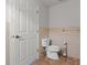 Bathroom featuring a toilet with a tiled floor, complemented by tiled walls and a convenient toilet paper holder at 2443 Lake View Blvd, Port Charlotte, FL 33948