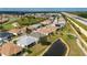 Aerial view of homes by the golf course, including pond, screened lanai, and solar panel features at 24576 Buckingham Way, Punta Gorda, FL 33980