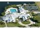 Aerial view showcasing the community pool, tennis courts, and surrounding buildings at 24576 Buckingham Way, Punta Gorda, FL 33980