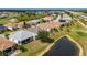 Aerial view of a home with a screened-in porch, surrounded by a golf course and a pond at 24576 Buckingham Way, Punta Gorda, FL 33980