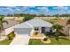 Well-manicured home exterior features a two-car garage and lush landscaping at 24576 Buckingham Way, Punta Gorda, FL 33980