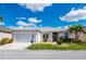 Well-maintained one-story home featuring a landscaped front yard and driveway at 24576 Buckingham Way, Punta Gorda, FL 33980