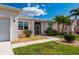 Front exterior showcasing lush landscaping, a well-manicured lawn, and a welcoming entrance at 24576 Buckingham Way, Punta Gorda, FL 33980
