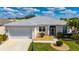 Charming one-story home with a well-maintained lawn, lush landscaping and a two-car garage at 24576 Buckingham Way, Punta Gorda, FL 33980
