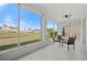 Enclosed lanai with seating offers serene views of the pond and landscaping at 24576 Buckingham Way, Punta Gorda, FL 33980
