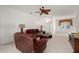 Cozy living room features a ceiling fan, plush sofas, and neutral carpet at 24576 Buckingham Way, Punta Gorda, FL 33980