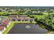 An aerial view of the apartment complex with lush landscaping and a scenic pond with fountain at 25100 Sandhill Blvd # J-201, Punta Gorda, FL 33983