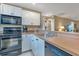 This well-lit kitchen features white cabinets, stainless steel appliances, and a breakfast bar at 25100 Sandhill Blvd # J-201, Punta Gorda, FL 33983