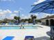 A view of the sparkling community pool with plenty of seating and shade at 25100 Sandhill Blvd # J-201, Punta Gorda, FL 33983