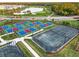 Birds eye view of a pickleball and tennis court surrounded by a golf course and gorgeous landscaping at 25186 Keygrass Ct, Punta Gorda, FL 33955