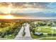Stunning aerial view of the community entrance, golf courses, and surrounding landscape at sunset at 25186 Keygrass Ct, Punta Gorda, FL 33955