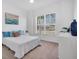 Sunlit bedroom featuring a white comforter, a large window and neutral decor at 25186 Keygrass Ct, Punta Gorda, FL 33955