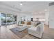 Open-concept living room with modern furnishings, tile flooring, and bright natural light at 25186 Keygrass Ct, Punta Gorda, FL 33955