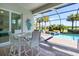 Screened patio with dining set overlooking the sparkling pool and lake view at 25186 Keygrass Ct, Punta Gorda, FL 33955