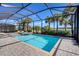 Sparkling screened-in pool area with palm tree views and lounge chairs at 25186 Keygrass Ct, Punta Gorda, FL 33955