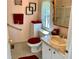 Cozy bathroom featuring a tile floor, vanity and toilet with red accents and accessories at 258 Palm Harbor Dr, North Port, FL 34287