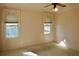 Bedroom showcasing two windows with light filtering through lace curtains and neutral carpet at 258 Palm Harbor Dr, North Port, FL 34287