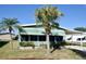 Charming single-story home with awnings, manicured landscaping, and mature palm trees at 258 Palm Harbor Dr, North Port, FL 34287
