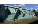 Exterior view showcasing green home with sun awnings providing shade at 258 Palm Harbor Dr, North Port, FL 34287