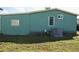 Rear exterior view showing an air conditioning unit and modest yard at 258 Palm Harbor Dr, North Port, FL 34287