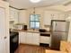 Well-lit kitchen with updated appliances, white cabinetry, and laminate countertops at 258 Palm Harbor Dr, North Port, FL 34287