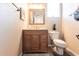 Cozy bathroom with wooden vanity, framed mirror, and a tiled floor at 27199 Punta Cabello Ct, Punta Gorda, FL 33983