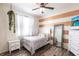 Cozy bedroom with stylish decor including a striped accent wall, ceiling fan, and wood-look flooring at 27199 Punta Cabello Ct, Punta Gorda, FL 33983