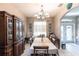 Traditional dining room is styled with a large china cabinet, chandelier, and views to the front entrance at 27199 Punta Cabello Ct, Punta Gorda, FL 33983