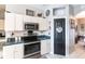 A well-lit kitchen featuring stainless steel appliances, white cabinetry and tile flooring at 27199 Punta Cabello Ct, Punta Gorda, FL 33983