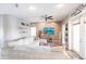 This cozy living room features an off-white L-shaped sofa, a ceiling fan and neutral walls at 27199 Punta Cabello Ct, Punta Gorda, FL 33983